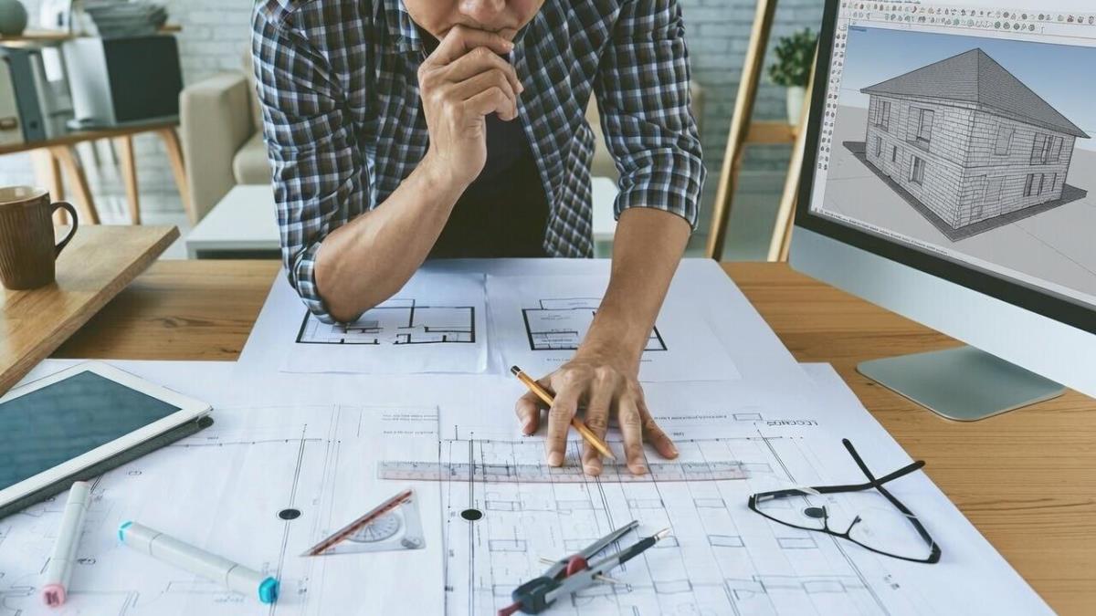 Проектирование кирпичных домов — архитектор работает над чертежами